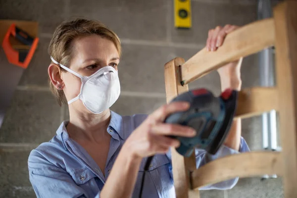 Mature Woman Upcycling Furniture Workshop Home Using Electric Sander — Stock Photo, Image