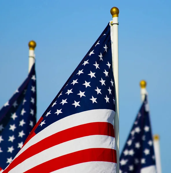 Tres banderas americanas en exhibición con postes blancos coronados por un gol —  Fotos de Stock