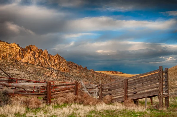 Dřevěný dobytek nakládací rampa sedí na stinné straně kopců — Stock fotografie