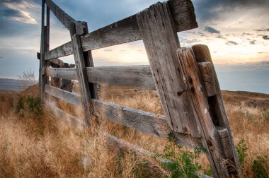 Old and dilapidated raw wooden fence in a high desert hilly sett
