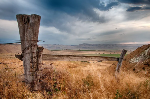 Velký sloup na konci ostnatého drátu plotu ve vysoké poušti hi — Stock fotografie