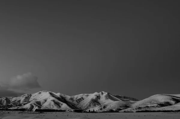 Monochromatické velmi časné světlo přes zasněžené hory — Stock fotografie