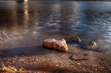 Sahildeki yansıtıcı sudan çıkan kum taşı kayaları.