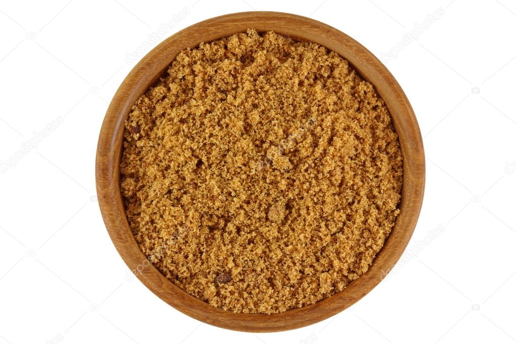 Unrefined unbleached natural Brown sugar in brown color in a wooden bowl