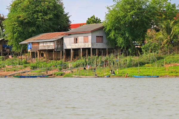 Case di legno su pali di cemento lungo la riva del fiume Mekong, Laos — Foto Stock