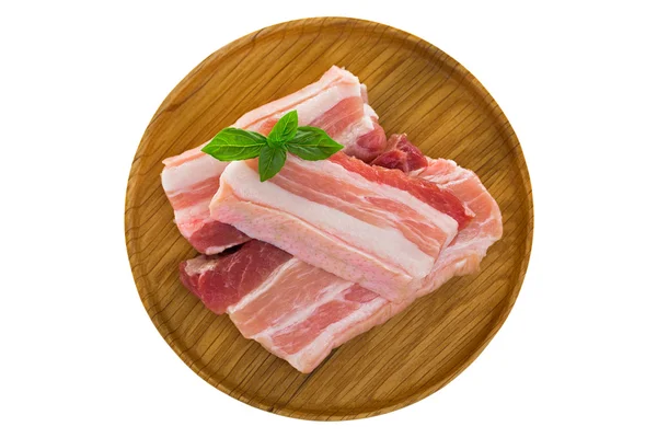 Slices of raw fresh pork belly cut on wooden plate isolated on white — Stock Photo, Image
