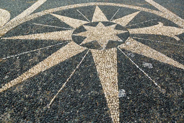 Pebble stone mosaic arranged in a symbol on pavement pedestrian street in Italy — Stock Photo, Image