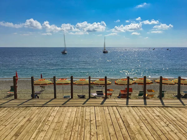 Sentiero pedonale in legno lungo coloratissimo ombrellone al mare mediterraneo — Foto Stock