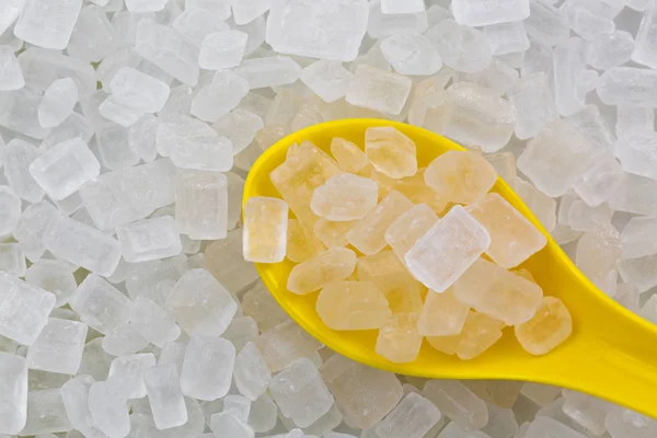 Cuchara amarilla llena de azúcar de roca blanca (caramelo de roca), azúcar cristalizada — Foto de Stock