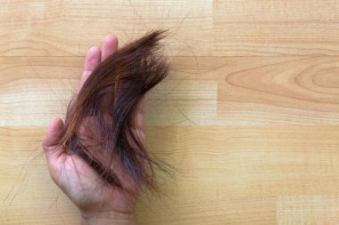 Asyalı kadın el kırpılmış kesilmiş kahverengi saçlı, kahverengi kırmızımsı avuç tutarak