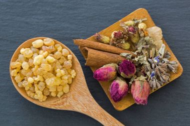 Tahta kaşık kuru çiçekler gül tomurcukları lavanta tarçın yanındaki aromatik sarı reçine sakız