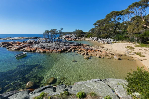 Turquoise waters rippled, lichen growing on granite rocks, rocky costline