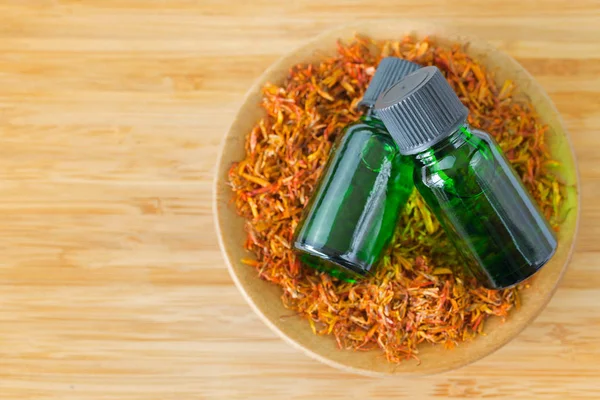 Pure Safflower essential concentrate oil extract in green bottle — Stock Photo, Image