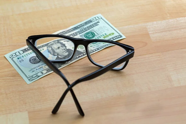 Spectacles with black frame, eye glasses on 20 USD dollar banknote money bil — Stock Photo, Image