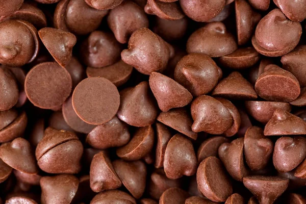 Texture macro of small chunks of sweetened chocolate chips background — Stock Photo, Image