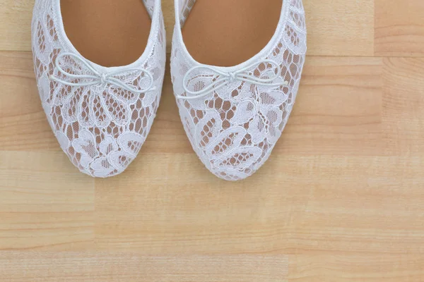 Białe koronki kwiatowy balet płaskie slip on buty na podłoże drewniane — Zdjęcie stockowe