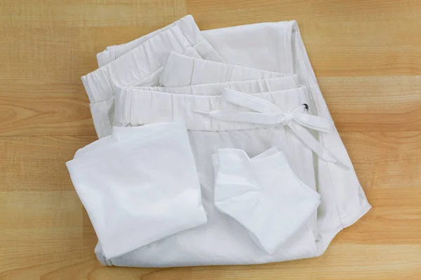 Weiße saubere Unterwäsche Höschen, Socken, Jogginghosen auf hölzernem Hintergrund — Stockfoto