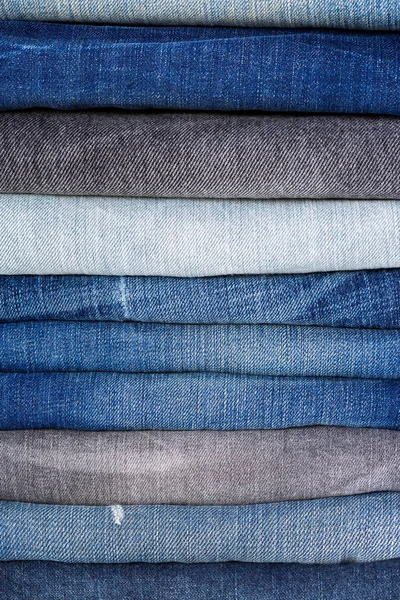 Stack of folded clothes, blue jeans pants texture, dark blue denim trousers