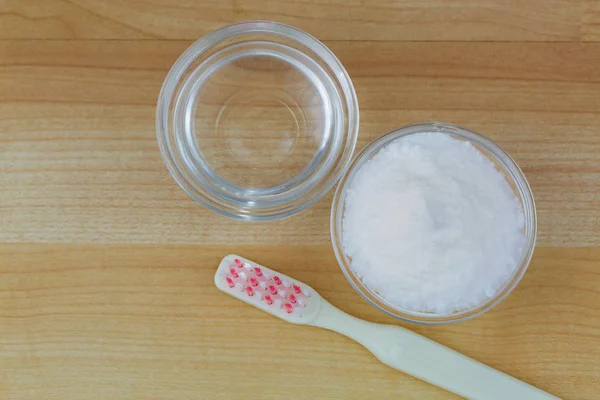 Bol de poudre de bicarbonate de soude, vinaigre à côté de la brosse à dents utilisée comme solution de nettoyage — Photo