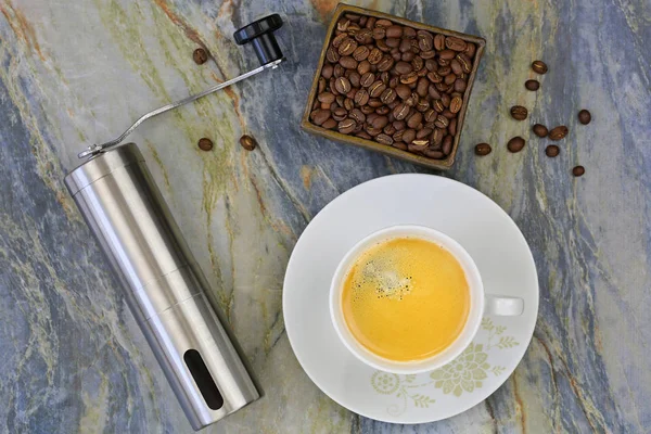 Kop warme koffie met hand coffee grinder aan bonen vermalen. — Stockfoto