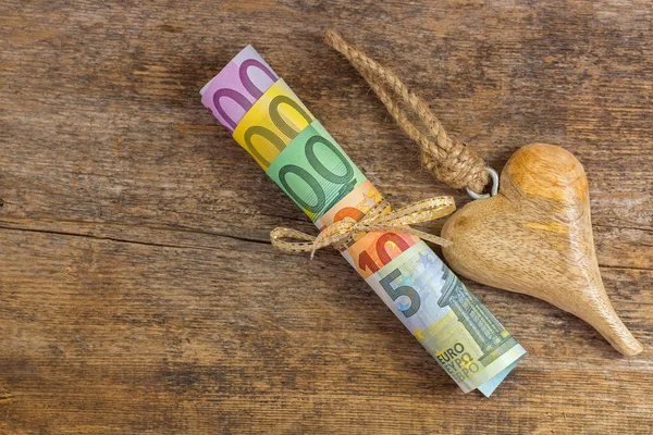 Different Euro banknote next to wooden heart with rope. Set of rolled European money — Stock Photo, Image