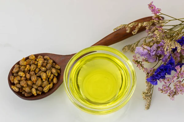 Huile de pépins de raisin pressée à froid biologique dans un bol transparent avec graines de colza séchées — Photo