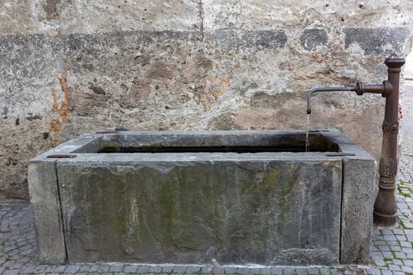 Oude rechthoek goed met stromend water uit fontein kraan in Glurns, Italië — Stockfoto