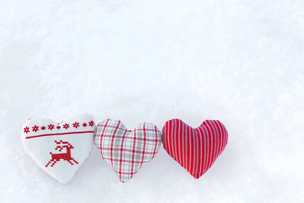 3 Tres corazones blancos con punto de cruz de invierno ciervos en rojo sobre nieve —  Fotos de Stock