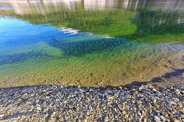 Frostad sten på lakeside med turkosa sjön vatten, vinter i Österrike — Stockfoto