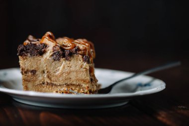 Bir fincan sıcak kakao ile servis edilen karamel soslu ekmek pudingi.