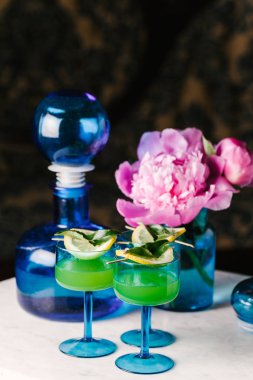 Mermer bir yüzeye üç ferahlatıcı tekila kokteyli.