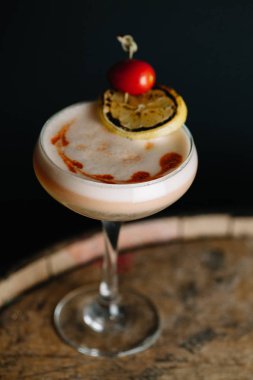Üzüm tomatıyla süslenmiş yumurta köpüklü alkollü kokteyl.