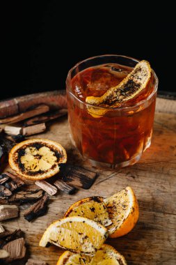 Koyu ahşap arka planda tütsülenmiş eski moda kokteyl.