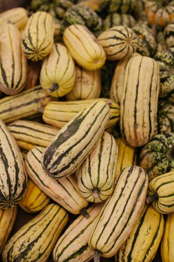 A pile of delicata squash on display at farmer's market 