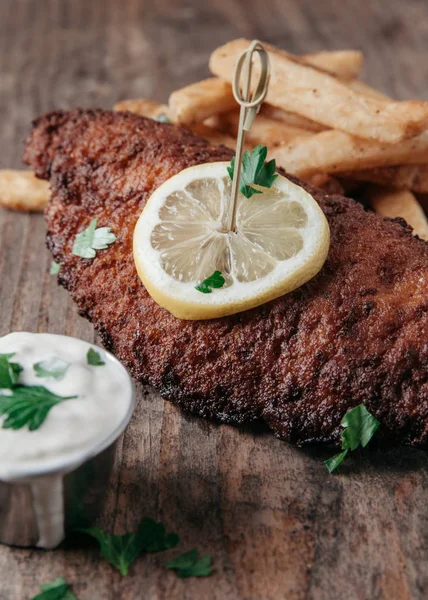 Peixe-gato frito servido com batatas fritas em fundo rústico — Fotografia de Stock