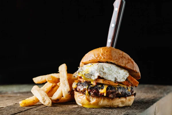 Breakfast burger with a fried egg on dark rustic surface, horizo — Stock Photo, Image