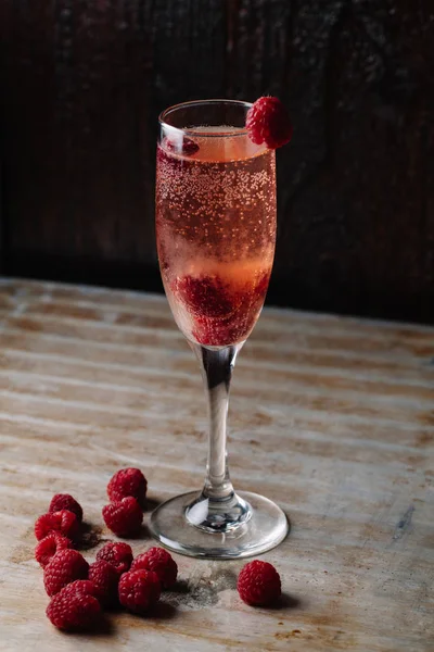 Un bicchiere di champagne al lampone su sfondo rustico — Foto Stock