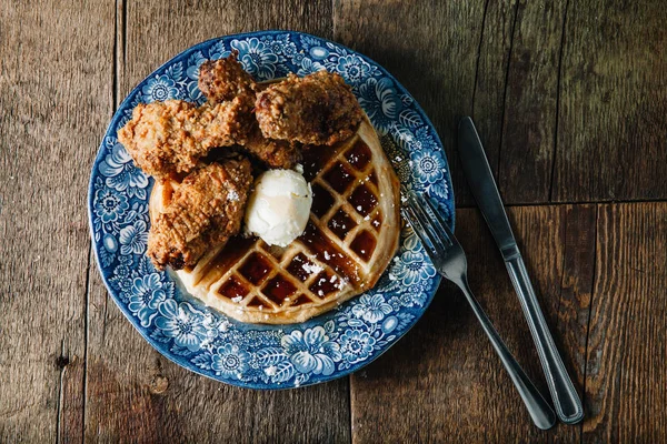 Tereyağı ve böğürtlen şurubuyla servis edilen tavuk kanatları ve waffle.