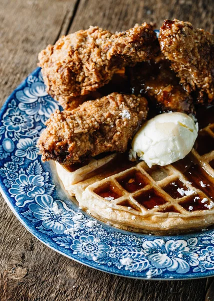 Tereyağı ve böğürtlen şurubuyla servis edilen tavuk kanatları ve waffle.