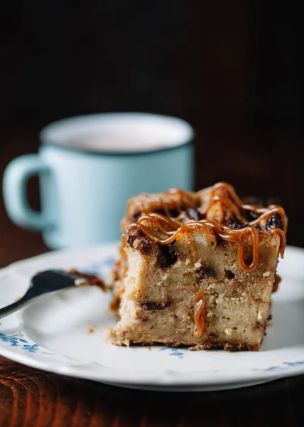 Bread pudding with caramel sauce served with a cup of hot cocoa — Stock Photo, Image