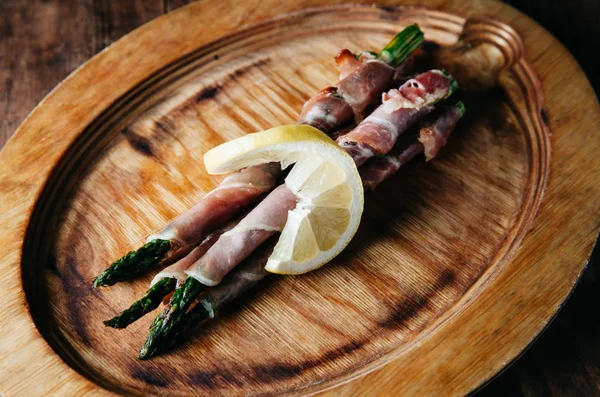 Bacon Wrapped Grilled Asparagus on a wooden plate — Stock Photo, Image