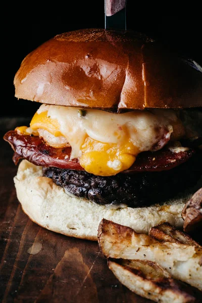 Hamburguesa de gran tamaño con chorizo y un huevo frito servido con francés —  Fotos de Stock