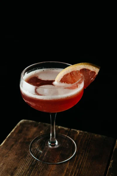 Pink cocktail garnished with a slice of blood orange on dark bac — Stock Photo, Image