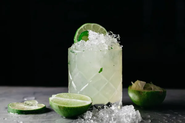 Summer alcoholic cocktail  with crushed ice garnished with limes — ストック写真