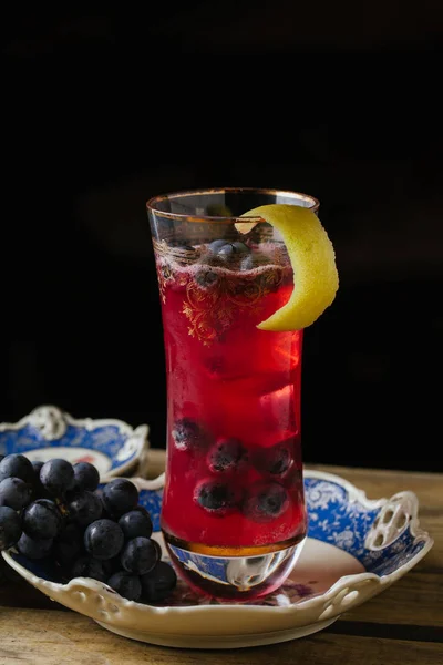 Coquetel de cor de cranberry decorado com uvas frescas em um prato vintage — Fotografia de Stock