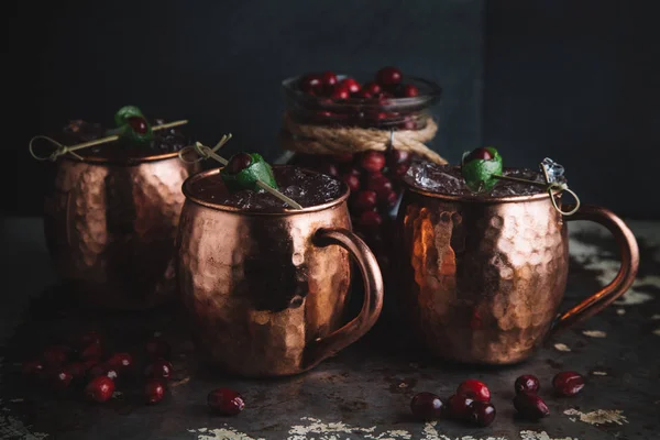 Moskva Mule cocktails utsmyckade med tranbär och lime — Stockfoto