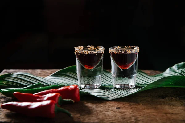 Two spicy tequila shots on rustic background — ストック写真