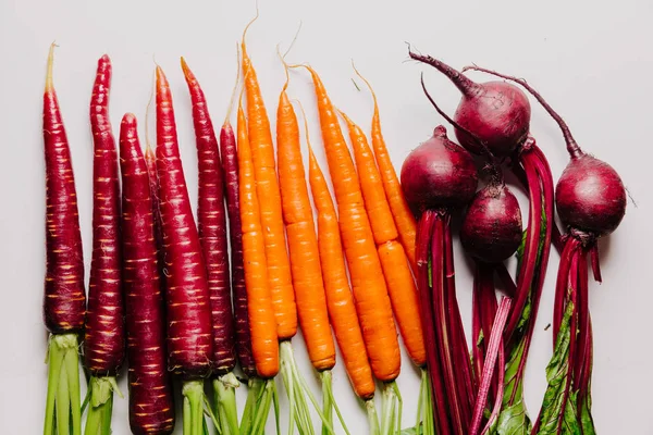 An assortment of loose raw beets and carrots 