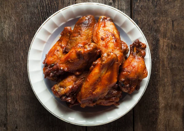 Un plato de alitas de pollo ahumadas con salsa de barbacoa confitada — Foto de Stock