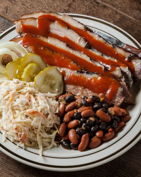 Un plato de brisket rebanado con frijoles horneados, ensalada de col y eneldo — Foto de Stock